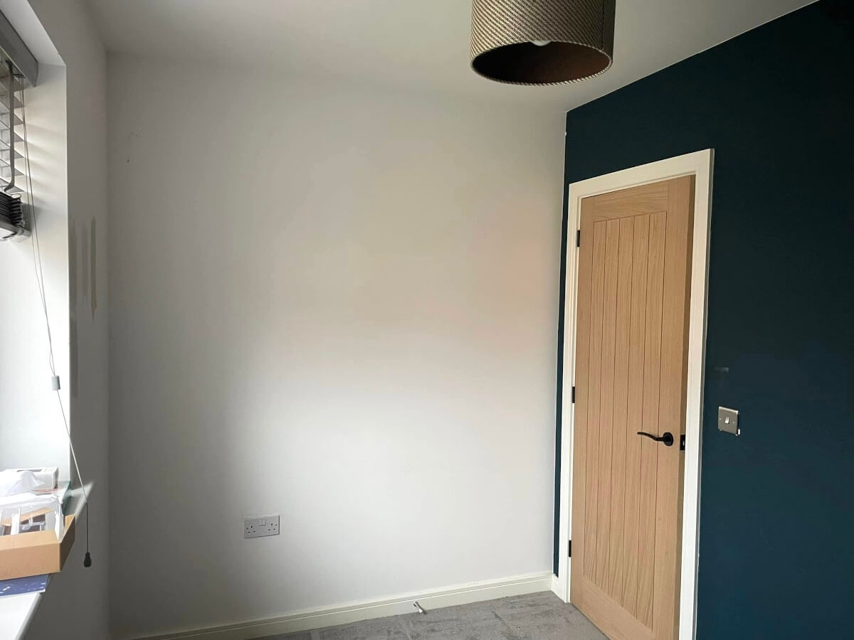 bedroom-white-navy-painted-walls-feature-wall-cardiff-primrose-decor Finished grey wall with a dark navy feature wall and an oak door in Cardiff