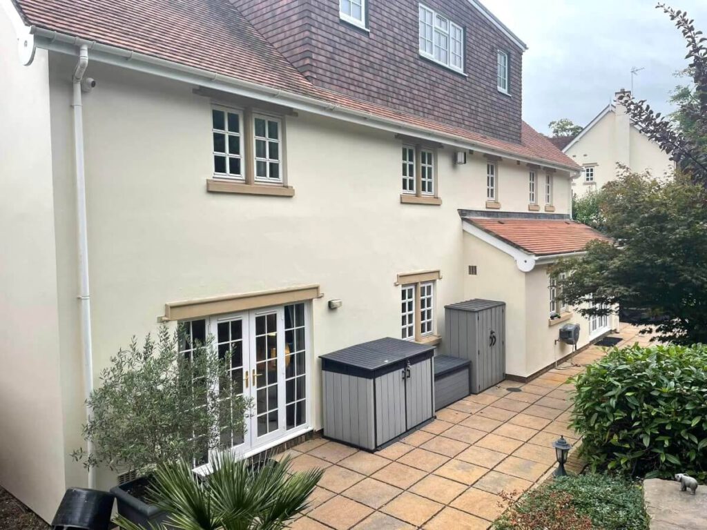 Cream painted exterior walls and white window frames on a detached house