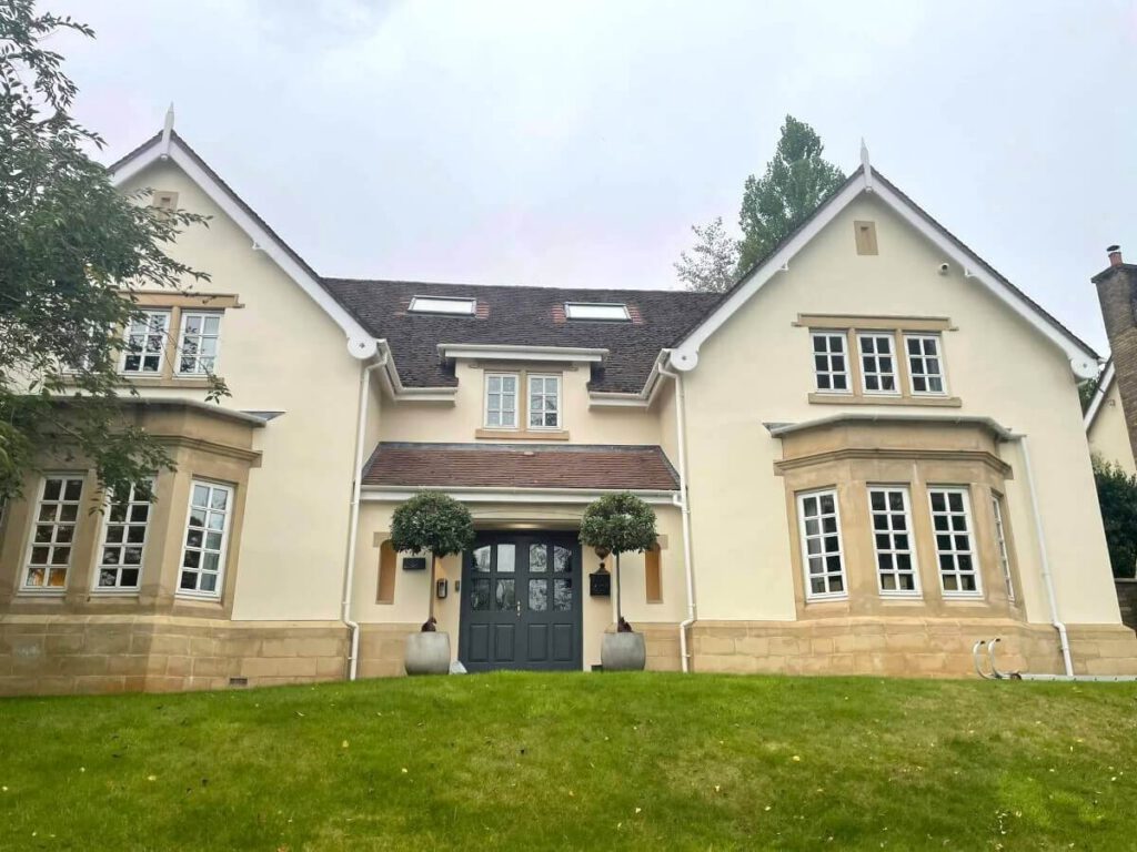 Cream painted exterior with detailed window surrounds and upper walls