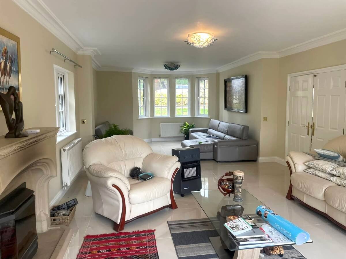 Living room with beige painted walls and bay window in Cardiff by Primrose Decor