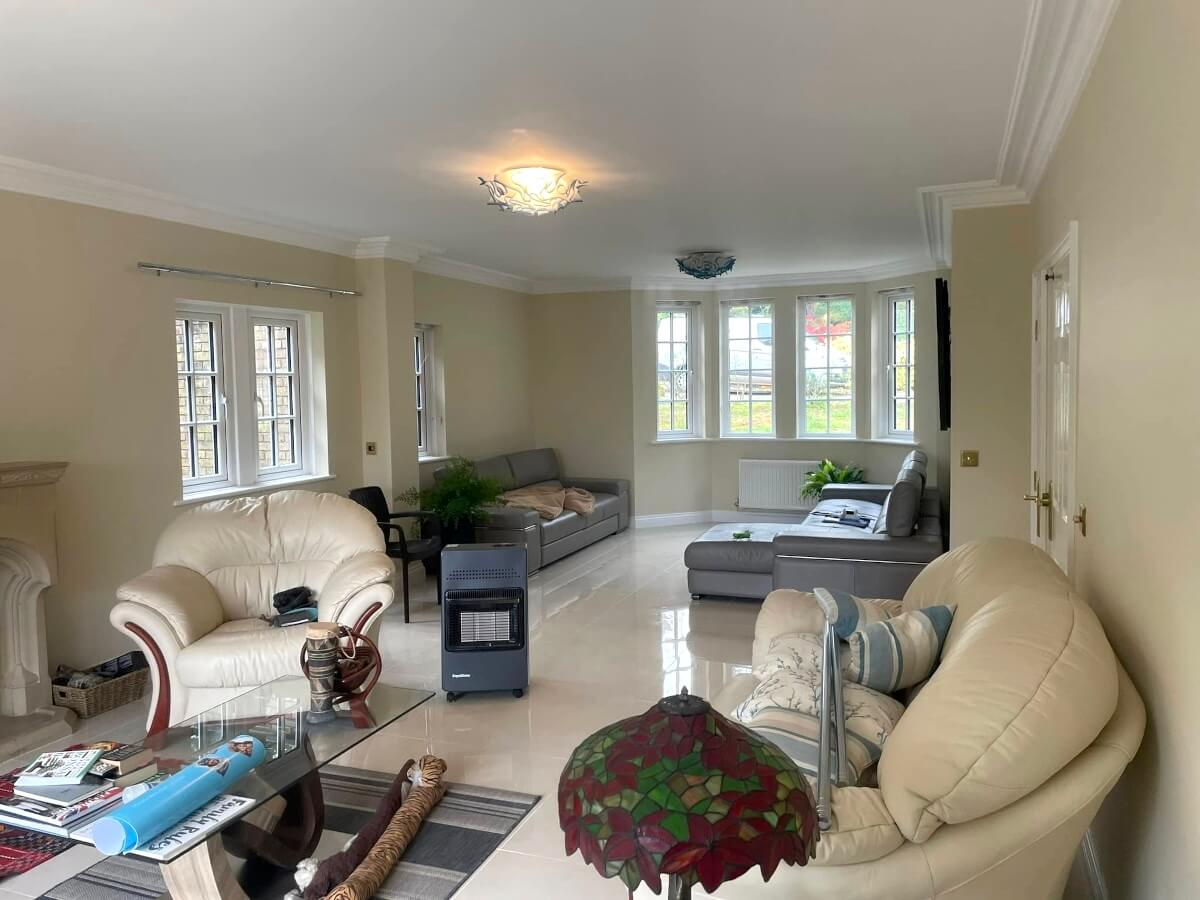 Living room with pale beige painted walls, white cornice and a bay window