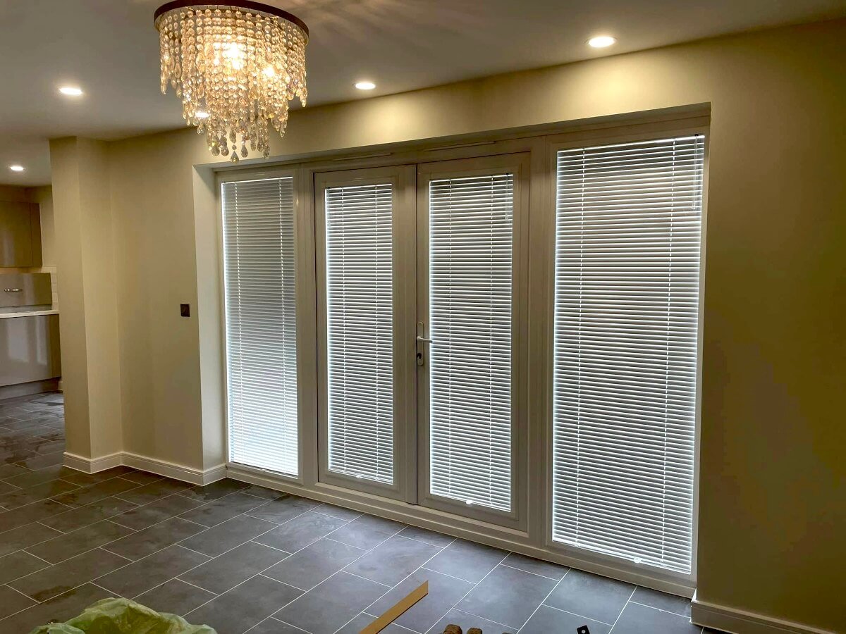 Living room with cream painted walls and bifold doors in Cardiff by Primrose Decor