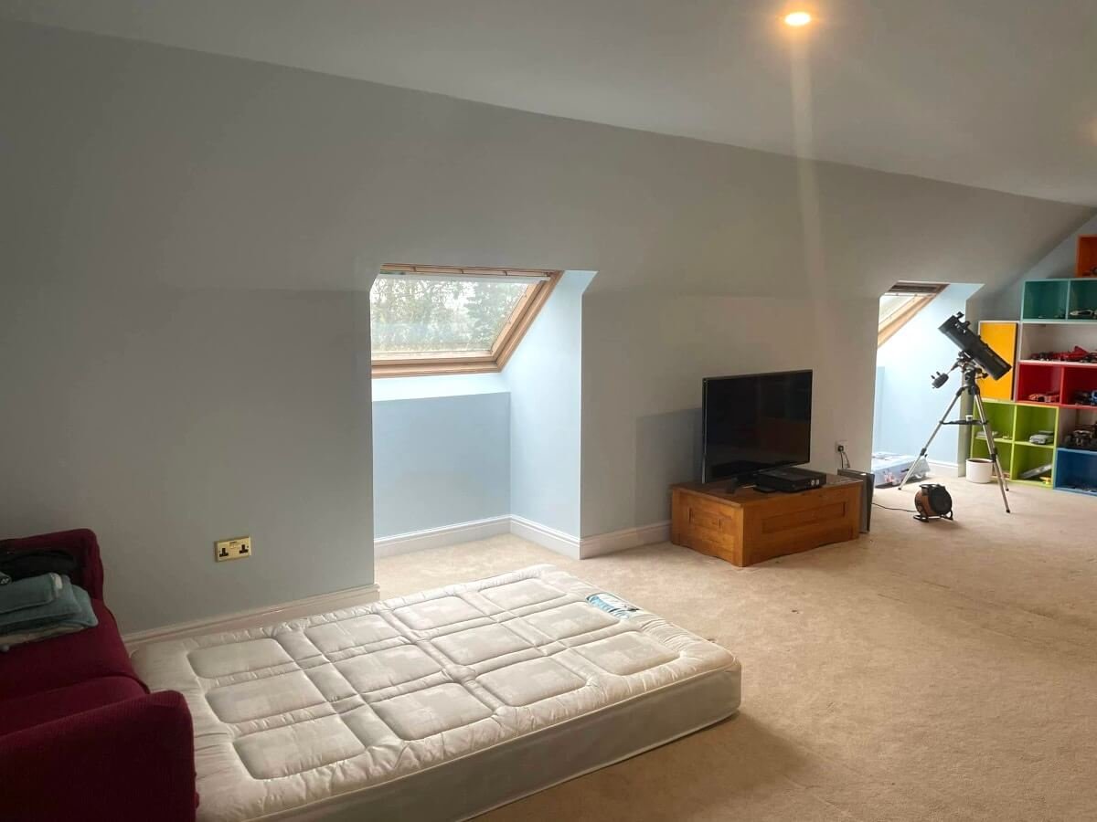 Loft room with grey and aqua painted plasterboard walls and skylights in Cardiff by Primrose Decor