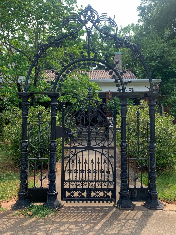 Black painted metal gate with decorative ironwork